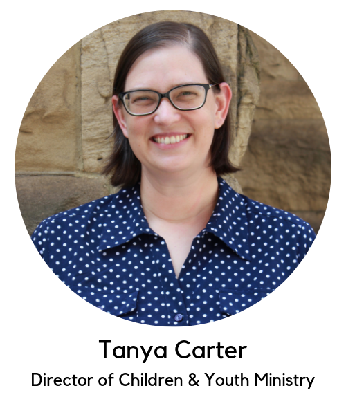 Tanya Carter, Director of children and youth ministry. White woman with brown hair, glasses, wearing a blue button up shirt with white polka dots.