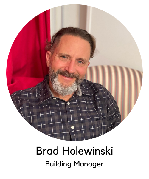 Brad Holewinski, building manager, white man with brown hair and grey beard. Wearing grey button down shirt